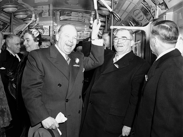 vintage men in suits riding subway talking laughing 