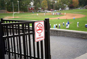 Photo of a practice field with a no smoking sign